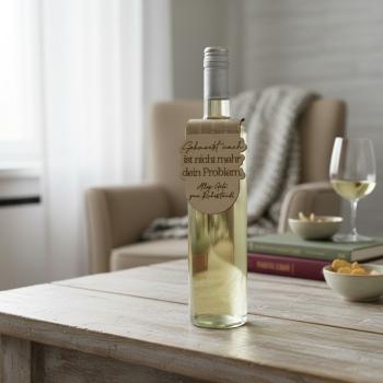 Handgefertigter Flaschenanhänger aus Birkenholz mit gelaserter Gravur zum Ruhestand, dekorativ an einer Weinflasche angebracht.